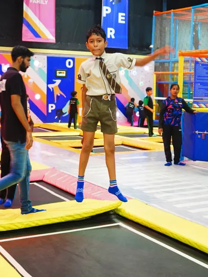 A student from a scout troop shows off his balancing skills on the edge of a trampoline.