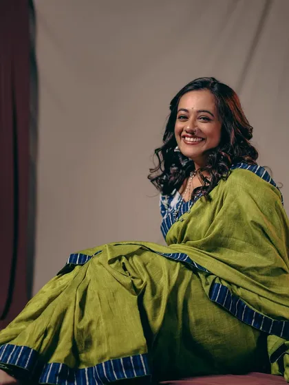 A joyful, relaxed shot from the same series, showing the comfortable and chic vibe of the handloom saree.