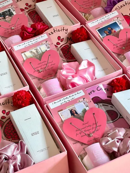 A delicate and thoughtful bridesmaid gift. This box includes a customized heart-shaped necklace, a satin scrunchie, a Zara pocket perfume, and a scented candle, all tied together with a personal photo card.
