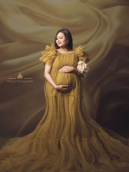 A fine art maternity portrait in a beautiful olive green tulle gown, creating a soft and elegant look.
