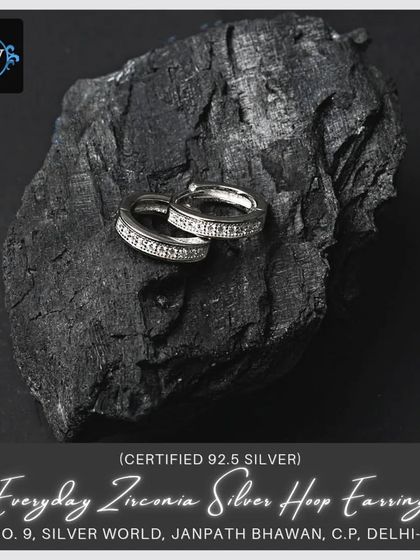 A slightly different angle of the zirconia hoops, emphasizing their sparkle against a dark, natural background.