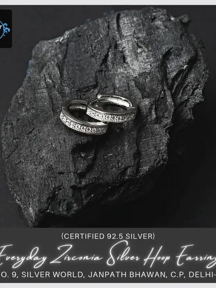 A slightly different angle of the zirconia hoops, emphasizing their sparkle against a dark, natural background.