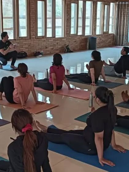 An asana practice session in our spacious, wood-paneled yoga hall at the Rishikesh ashram.