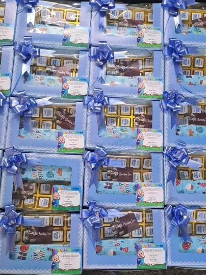 First birthday return gifts don't have to be expensive. These Cocomelon-themed boxes are a great budget-friendly choice, filled with chocolates and other treats.
