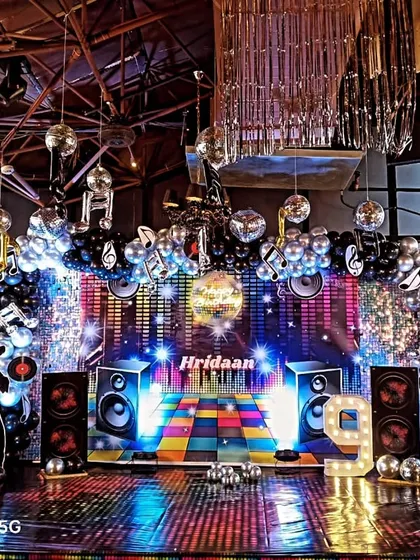 This is a full disco-themed party setup I designed. It features a custom LED screen backdrop, silver disco balls, and themed cutouts to create a high-energy environment perfect for office celebrations and milestone parties.