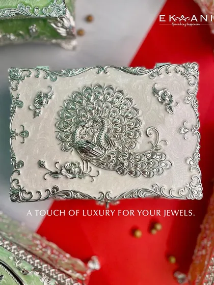 A touch of luxury for your jewels. The peacock enamel box in a classic pearl white, offering a timeless and elegant storage solution.