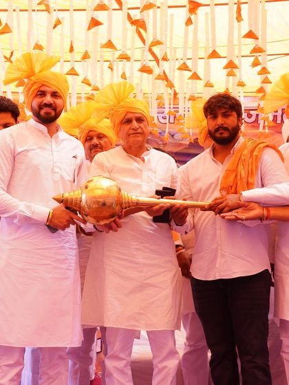 Being honored with a traditional 'Gada' at the community event, a symbol of strength and responsibility.