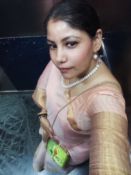 An elegant elevator selfie capturing the festive spirit. This soft pink organza saree, paired with a classic pearl necklace, is a testament to timeless grace, perfect for celebrating Durga Puja.