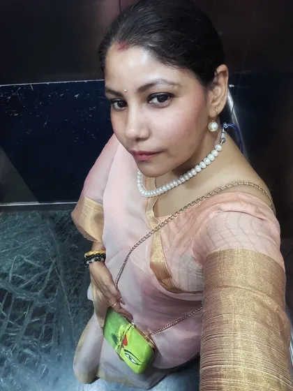 An elevator selfie showing the saree and a unique, artistic clutch, proving that great style is in the details.