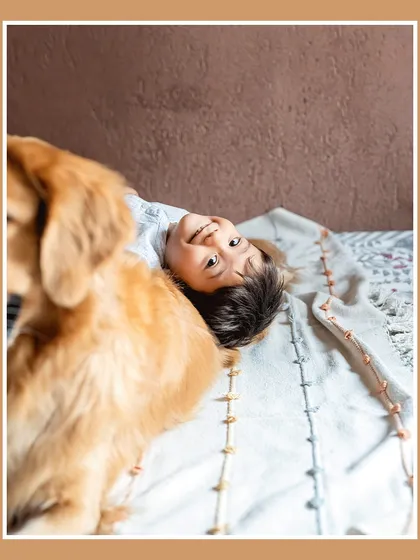 A sweet, stolen moment from Krishiv's perspective. Lying on the bed, he looks up with a happy smile as his Golden Retriever friend watches over him. These are the quiet, in-between moments I love to capture.