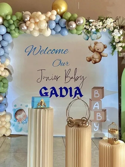 A personalized 'Welcome Home' backdrop for junior baby Gadia. We used a gentle blue and green color palette, teddy bear motifs, and custom lettering to create a sweet and personal focal point for the celebration.
