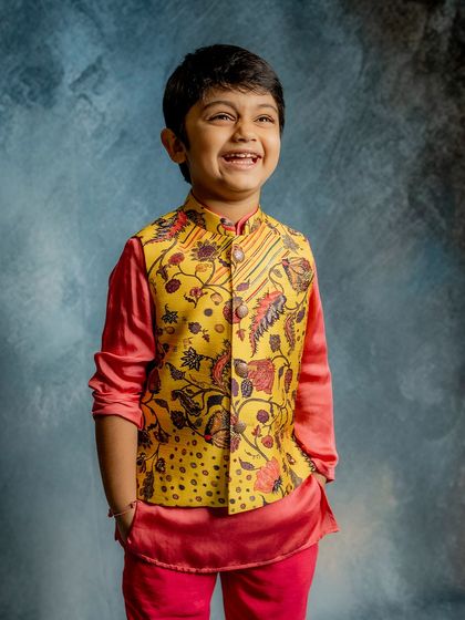 A smile that lights up the room. This young model looks joyful in our yellow and pink printed Bundi set, a vibrant and playful choice for any celebration.