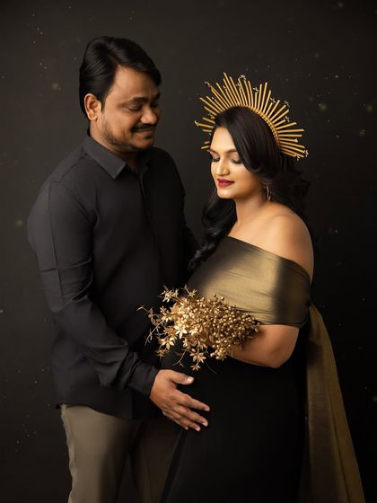 A beautiful fine art portrait of a couple. The mother-to-be, wearing a golden crown, looks like a queen, and her partner looks at her with adoration.