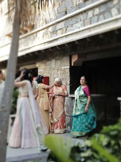 A candid moment of wedding guests, including elderly family members, interacting and observing the festivities.