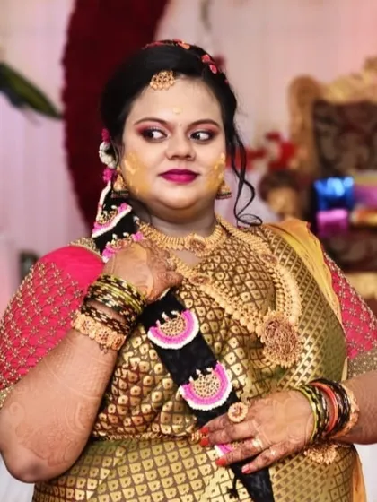 A happy client at her Sreemantham. This photo showcases her full look, including the intricate floral hair braid, traditional gold jewellery, and radiant makeup that lasted throughout the event.