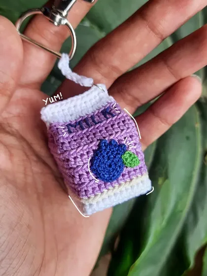 A fun, doodled-on photo of the blueberry milk keychain. Yum! It's a tasty-looking little charm.