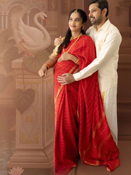 A hopeful portrait of a couple looking towards the future, dressed in traditional attire against a painted backdrop.