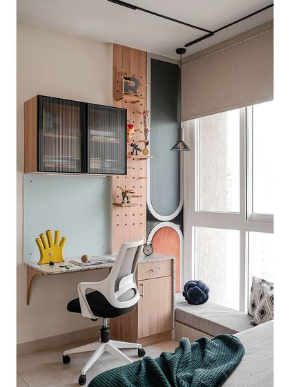 This compact study nook is perfect for a growing mind. The terrazzo-topped desk adds a pop of texture, echoing the room's palette of rust, green, and grey. A playful pegboard above is both fun and functional.