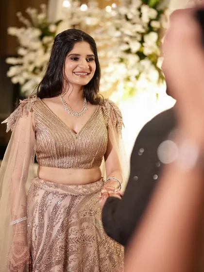 A sweet moment during the ring ceremony. The soft lighting enhances her glowing skin and the subtle shimmer of her makeup.