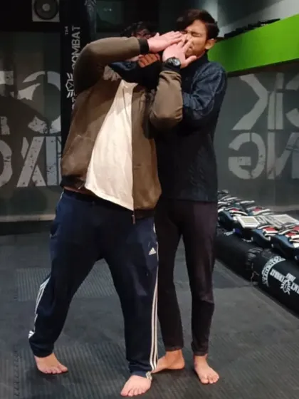 During a class, I am explaining the key principles of a headlock defense. The goal is to turn into the attacker to relieve pressure and create an opening for counter-strikes.