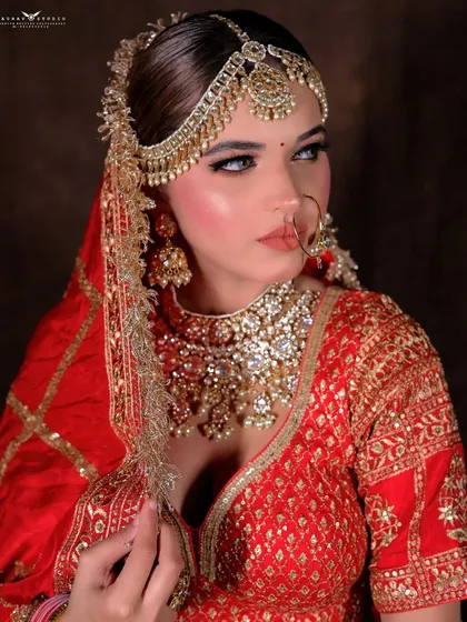 A striking close-up focusing on the bride's profile and the intricate details of her matha patti.