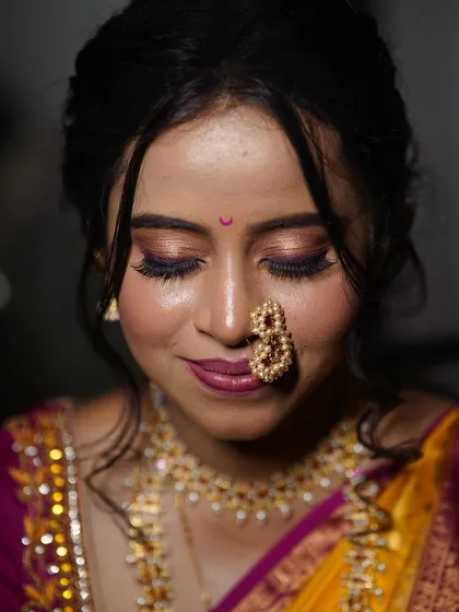A close-up on the eyes. I created a soft, shimmery eye look to enhance her features, paired with a bold nath for that perfect traditional touch.
