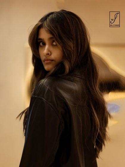 This shot captures a sense of movement and mystery, with a slightly blurred background and a sharp focus on the model's face.