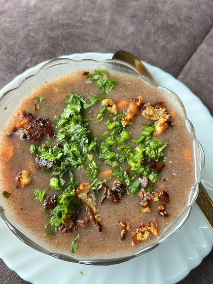 A bowl of ragi soup topped with fresh herbs, a great low-calorie option for a healthy diet plan.