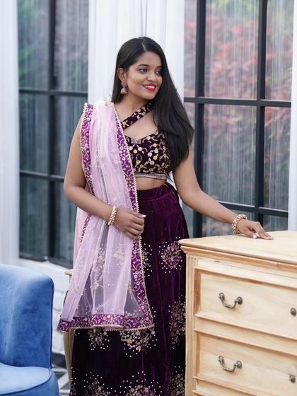 This portrait showcases the beautiful drape of the dupatta and the rich velvet fabric of the lehenga, a popular choice for pre-wedding functions.