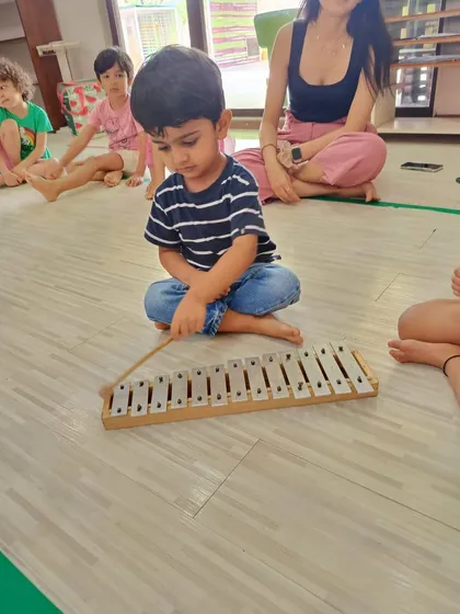 A young boy in our Bandra workshop concentrates as he plays a metallophone. These moments of focused play are where musical skills begin to develop.