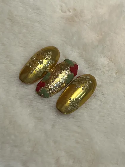 A different view of the gold chrome Christmas nails, showing how the light catches the glitter and texture.