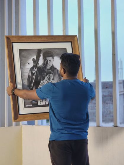 Holding up the framed 'Ghost' sketch.