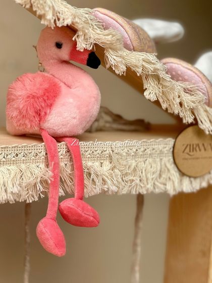 A close-up of the details that make my hampers special. This pink flamingo plush toy adds a touch of whimsy and charm to a baby girl's gift.