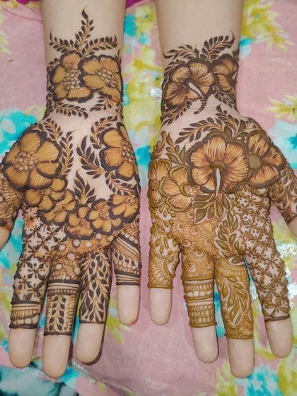 A vibrant floral design where one hand shows the fresh paste and the other shows the beautiful orange-brown stain after a few hours.