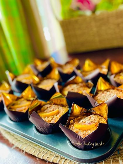 Another view of the golden-brown peach and carrot muffins in their tulip liners.