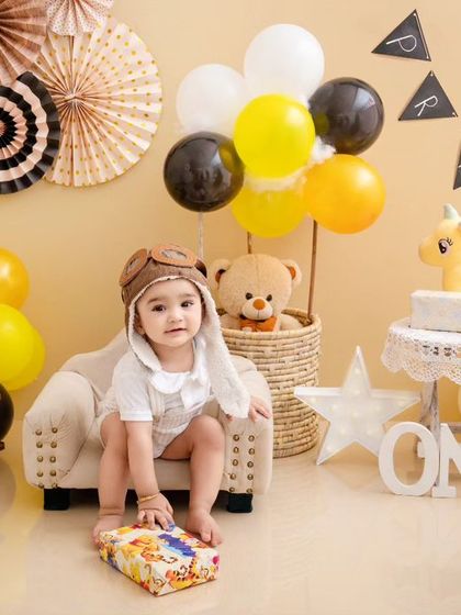 This little pilot is celebrating his first birthday with a travel-themed setup, complete with a toy plane and hot air balloon basket.