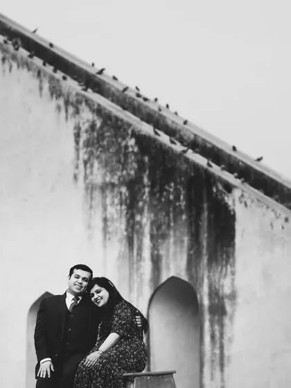 A classic black and white portrait at Jantar Mantar in Delhi. The historic monument adds a sense of timelessness to their story.