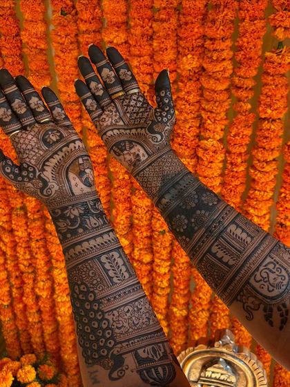 A full view of the intricate bridal mehendi, showcasing a mix of peacocks, grids, and personalized figures.