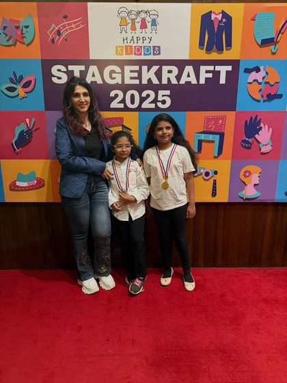Two proud performers showing off their medals. Their dedication during rehearsals really paid off.