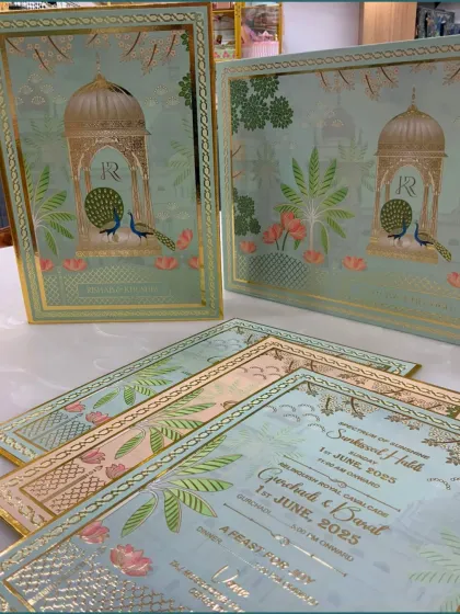 A closer view of the wedding invitation cards, showcasing the intricate gold foil work and the personalized details for the wedding events.