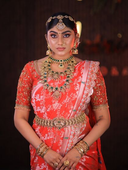 This stunning red floral saree is styled for a high-fashion bridal shoot. The drape is immaculate, designed to look dramatic and beautiful on camera.