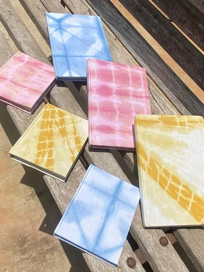 A collection of my tie-dyed notebooks, showcasing the different colors and patterns. They are a beautiful blend of function and artistry.