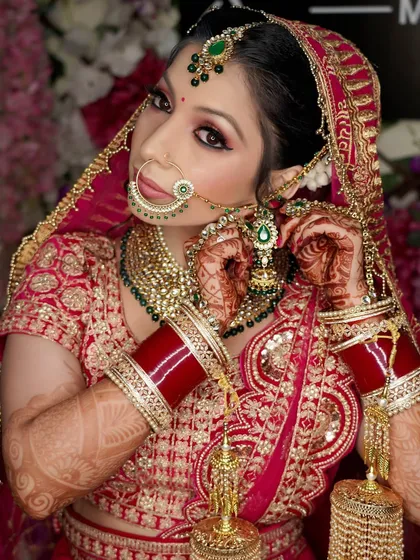 The final touches. This photo shows the bride putting on her earring, a classic moment that signifies she is almost ready for her big day.