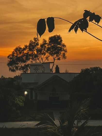 The silhouette of our ashram against a fiery sunset. This is the peaceful view that greets you at the end of each day, a perfect moment for reflection.