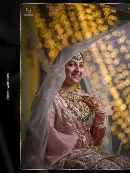 A classic bridal portrait of Prachi under her veil. The soft light, the beautiful bokeh background, and her gentle smile come together to create a dreamy and elegant image.