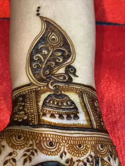 A still shot of the unique peacock and jhumka design. The combination of the bird and the earring motif creates a beautiful and symbolic piece of art on the arm.