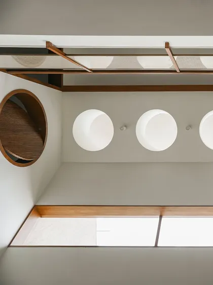 A worm's-eye view looking up at the ceiling's architectural details. The circular skylights and a unique pivoting circular window are geometric elements that add character and functionality.