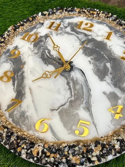 A bold and beautiful clock with a black, white, and grey marble design, framed by a border of multi-colored stones.