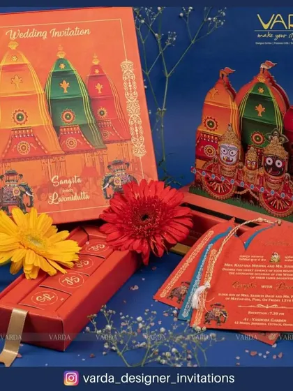 Another perspective of our Jagannath-themed pop-up invitation box. This view showcases the intricate details of the chariots and the accompanying invitation cards, which feature tassels and traditional motifs.