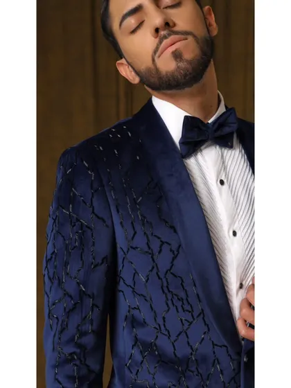 A close-up of the Luxe Blue Velvet tuxedo, showcasing the intricate black glass embellishments that create a subtle, textured pattern across the rich velvet fabric.
